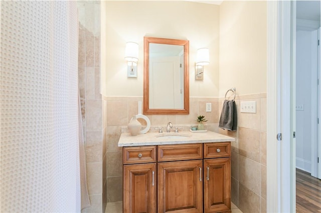 bathroom featuring wood-type flooring, curtained shower, tile walls, and vanity