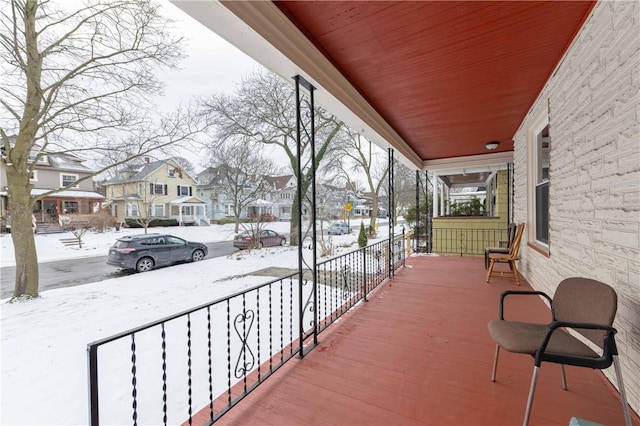 snow covered patio featuring a porch