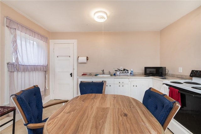 kitchen featuring white cabinets, white range with electric cooktop, sink, and light tile patterned floors