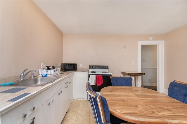 kitchen featuring light tile patterned floors, sink, and white cabinetry