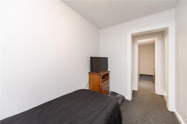 unfurnished bedroom featuring dark carpet and a textured ceiling