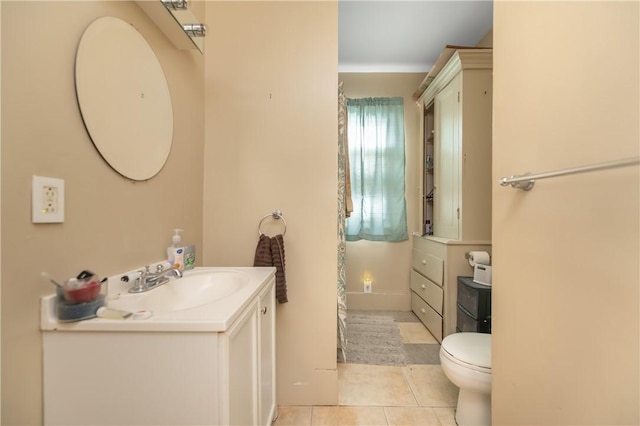 bathroom with toilet, vanity, and tile patterned floors