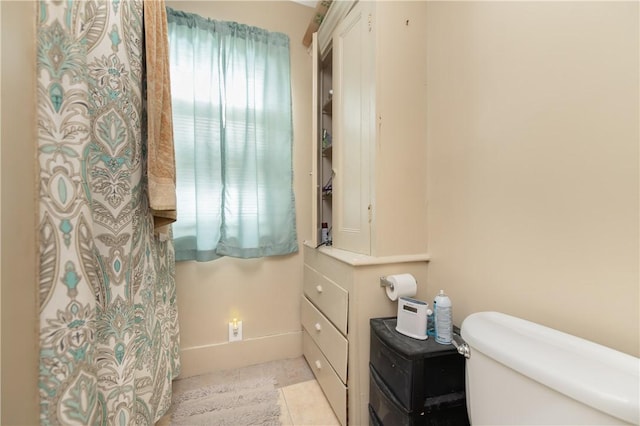 bathroom with toilet and tile patterned flooring