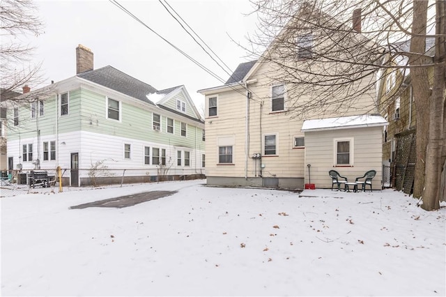 view of snow covered rear of property