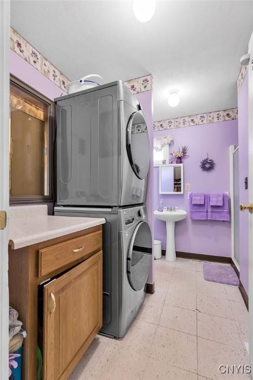 laundry room featuring stacked washer / dryer and sink