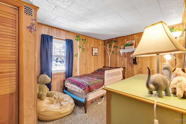 carpeted bedroom with wooden walls