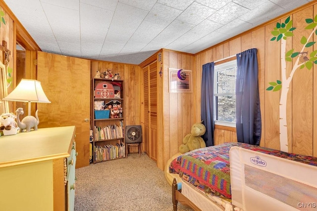 bedroom featuring carpet, a closet, and wooden walls