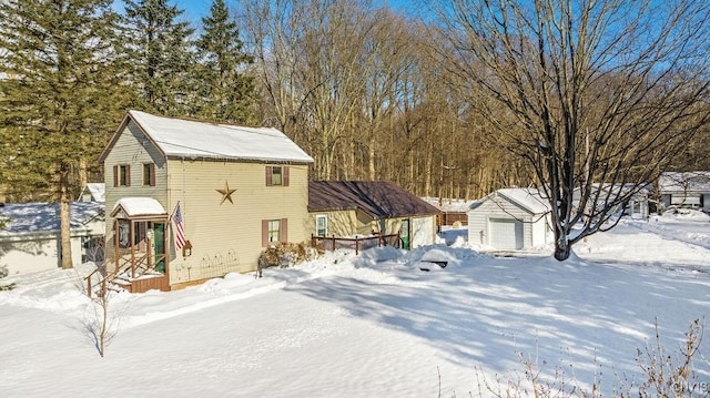 view of snowy exterior with a garage and a storage shed