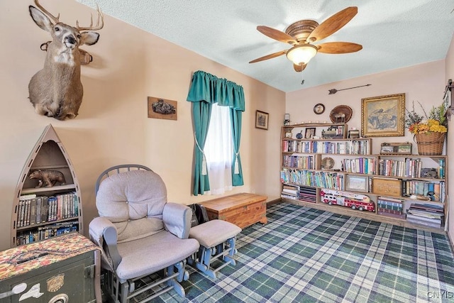 sitting room featuring ceiling fan and a textured ceiling