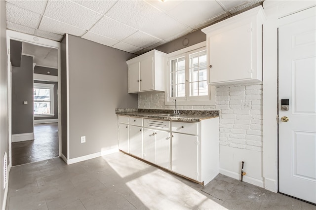 kitchen with sink, white cabinetry, and a paneled ceiling