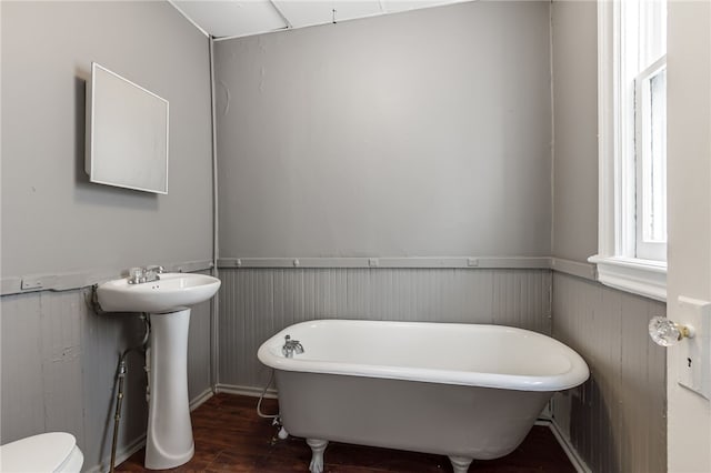 bathroom with toilet, a bathtub, hardwood / wood-style flooring, and sink