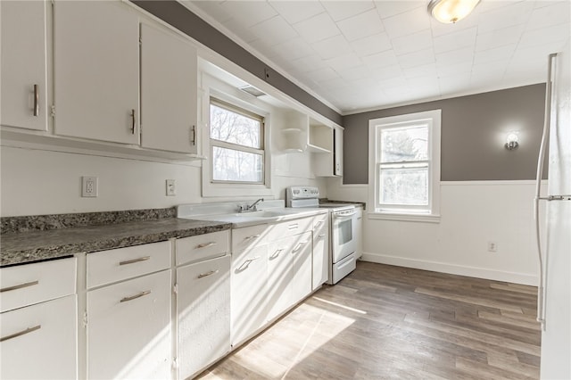 kitchen with hardwood / wood-style flooring, electric range, crown molding, white cabinets, and sink