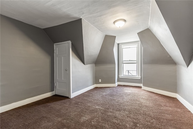 additional living space featuring vaulted ceiling and dark carpet