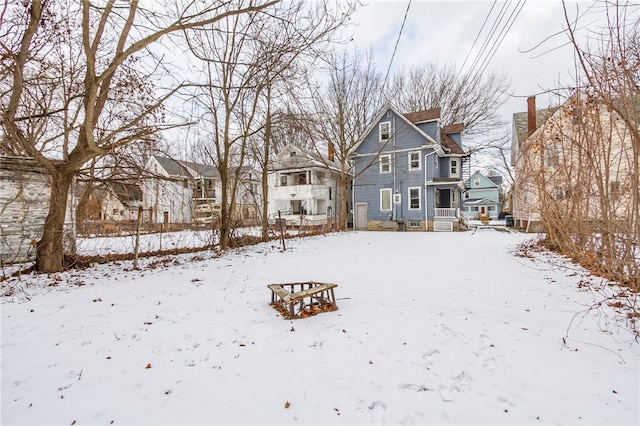 view of snow covered back of property