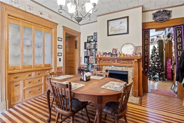 dining room featuring a high end fireplace, ornamental molding, and a chandelier