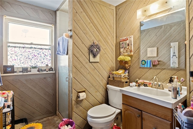 bathroom featuring a shower with door, toilet, vanity, and wooden walls