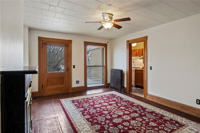 doorway with radiator, ceiling fan, and dark hardwood / wood-style flooring