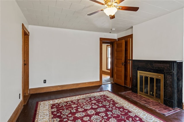 living room featuring dark wood-type flooring, a tile fireplace, and ceiling fan