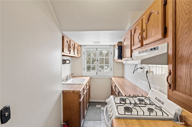 kitchen with sink, backsplash, and white gas stove