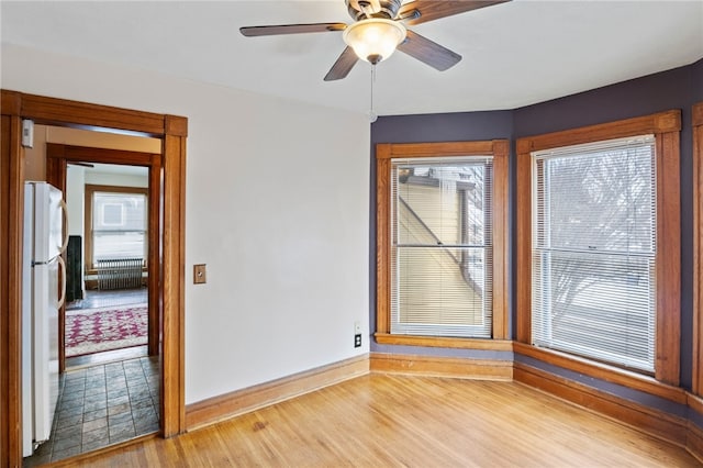 empty room featuring ceiling fan and hardwood / wood-style floors