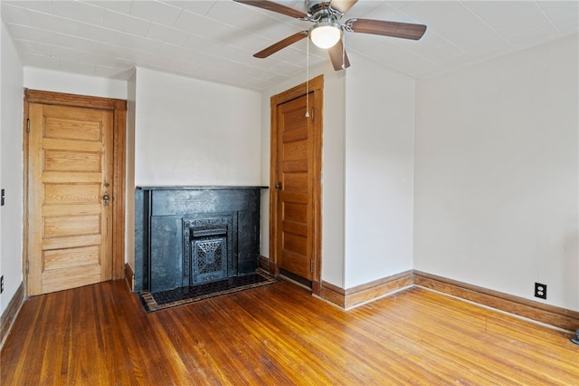 unfurnished living room with ceiling fan and wood-type flooring