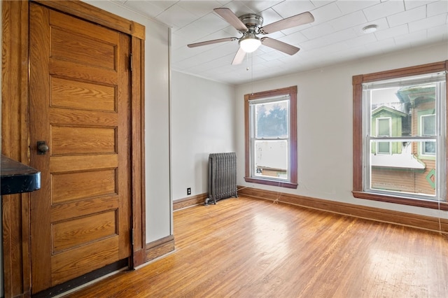 spare room featuring ceiling fan, light hardwood / wood-style flooring, and radiator