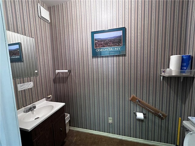 bathroom with wood-type flooring, toilet, and vanity