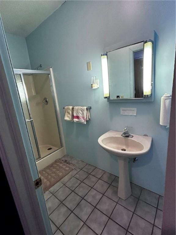 bathroom with sink, a shower with shower door, and tile patterned floors