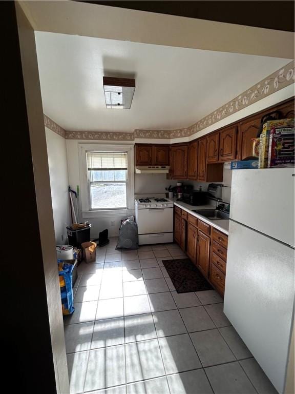 kitchen featuring sink, white appliances, and light tile patterned floors