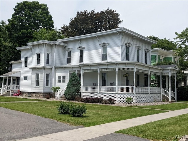 italianate-style house featuring a front yard and a porch