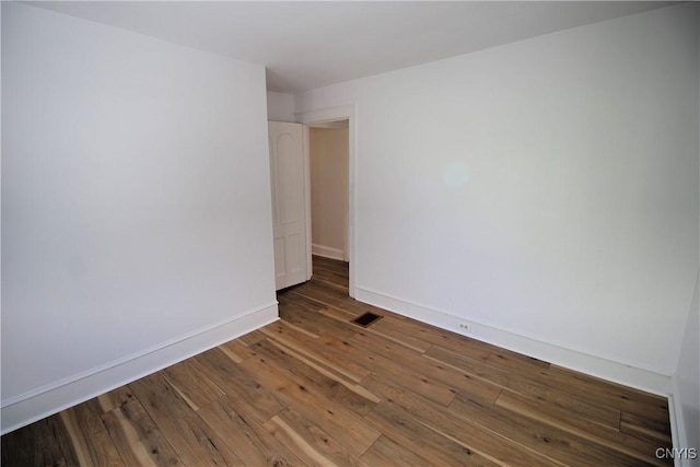 spare room with dark wood-type flooring