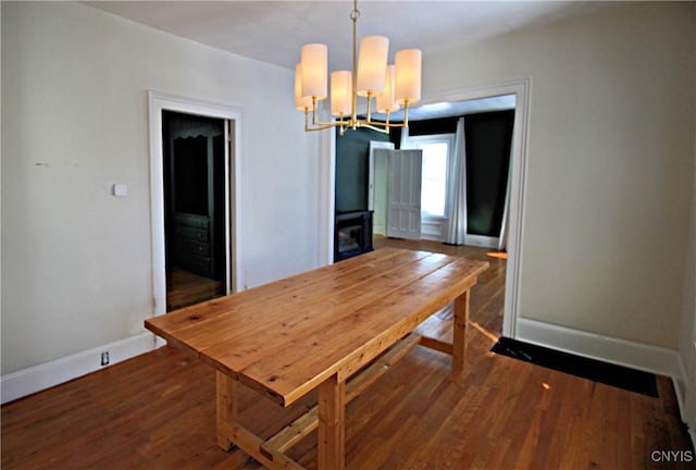 unfurnished dining area with dark hardwood / wood-style flooring and an inviting chandelier