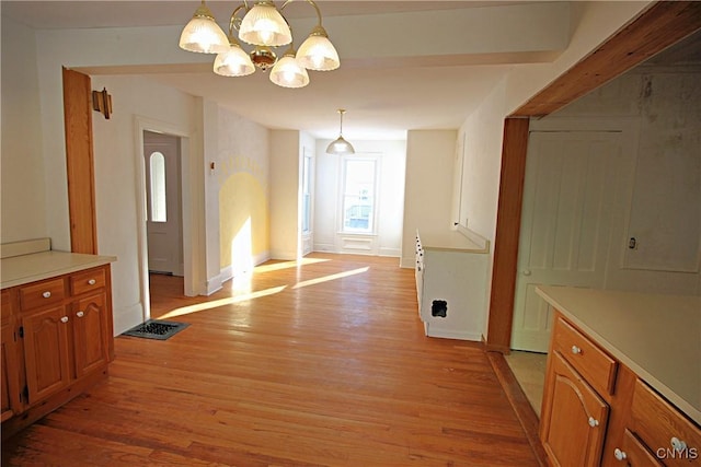 unfurnished dining area with a chandelier and light hardwood / wood-style flooring