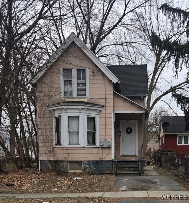 victorian home with entry steps and roof with shingles