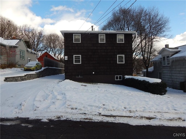 view of snow covered back of property