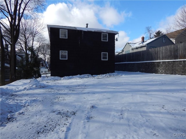 view of snow covered back of property