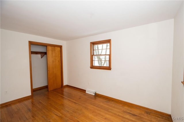 unfurnished bedroom with a closet and hardwood / wood-style floors