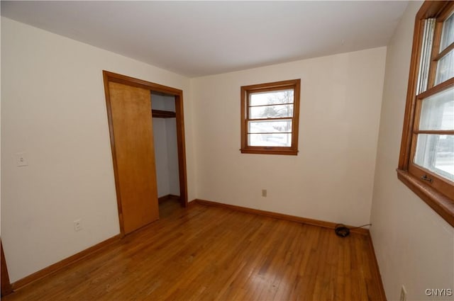 unfurnished bedroom with light hardwood / wood-style flooring and a closet