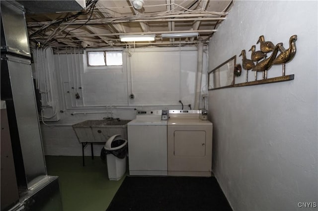 laundry area with sink, heating unit, and washing machine and dryer