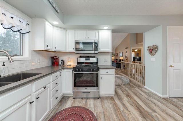 kitchen with sink, white cabinets, light hardwood / wood-style flooring, and stainless steel appliances