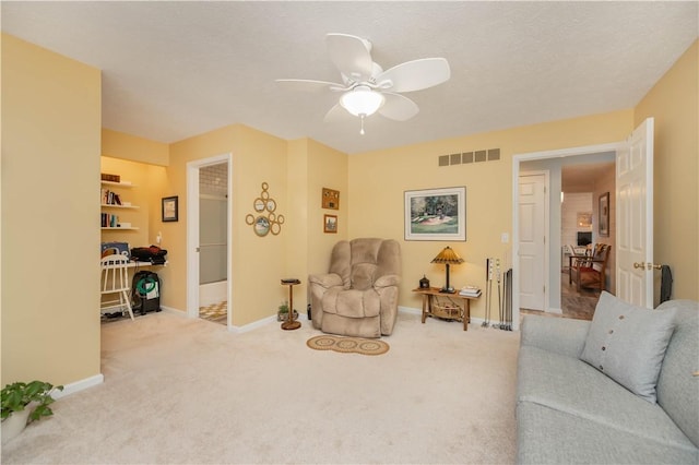 carpeted living room with a textured ceiling and ceiling fan