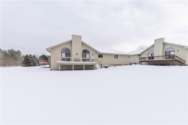 snow covered property featuring a wooden deck