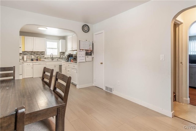 dining room featuring sink and light wood-type flooring