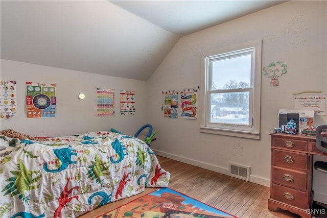 bedroom featuring light hardwood / wood-style flooring and lofted ceiling