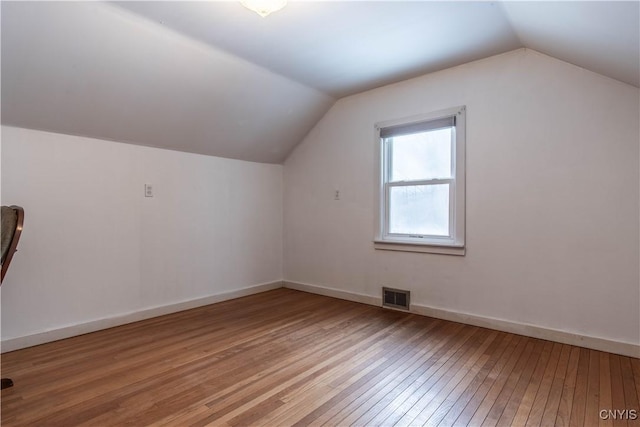 additional living space featuring light hardwood / wood-style flooring and lofted ceiling