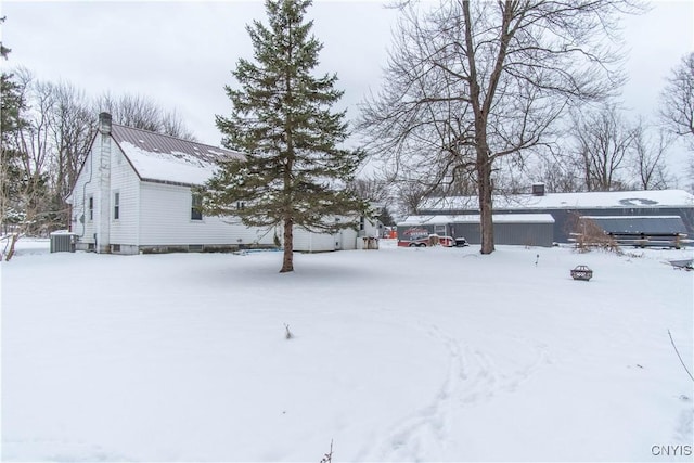 yard layered in snow featuring central AC