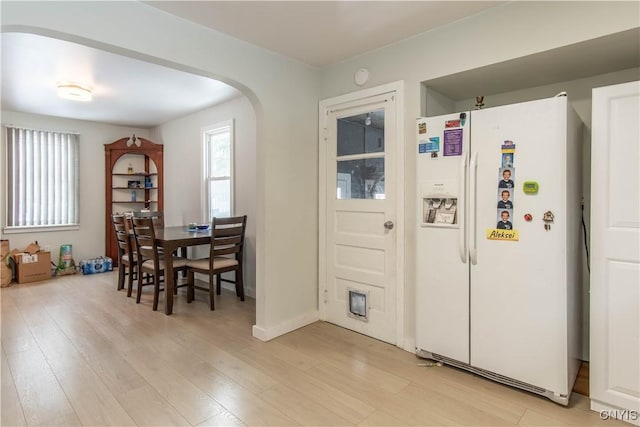 kitchen with white fridge with ice dispenser and light wood-type flooring