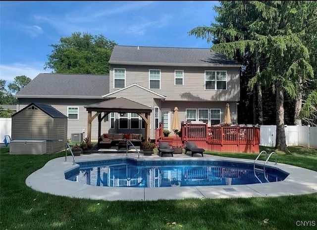 back of property featuring a lawn, a swimming pool side deck, a gazebo, and outdoor lounge area