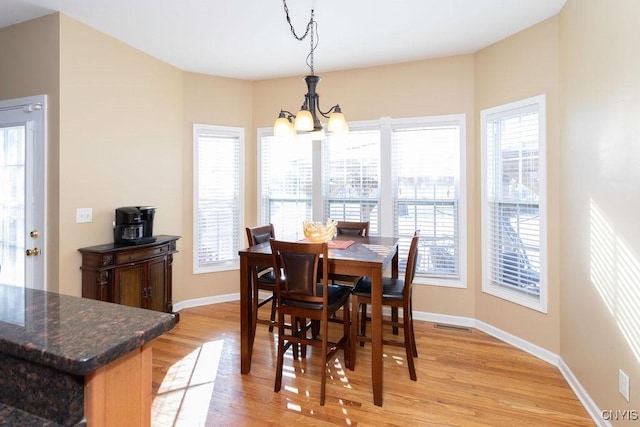 dining area with a notable chandelier and light wood-type flooring