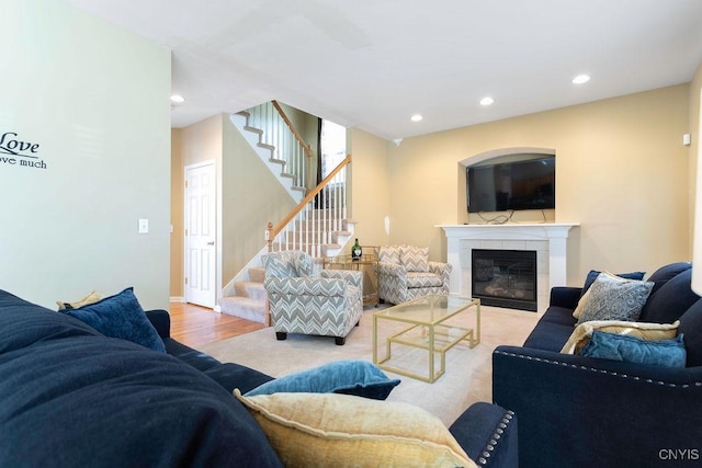 living room featuring light hardwood / wood-style flooring and a tiled fireplace